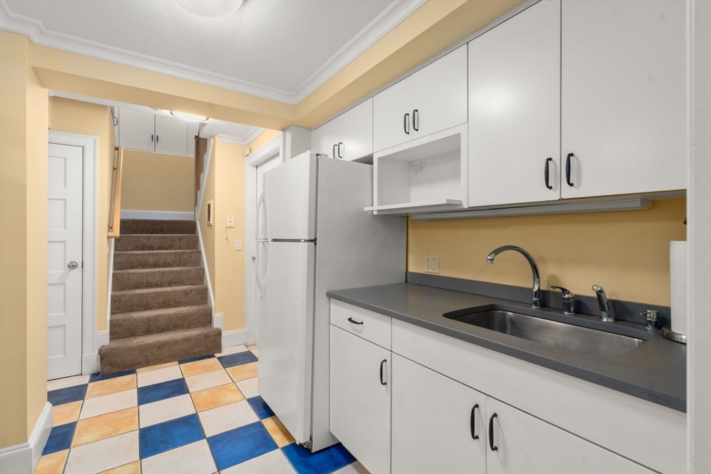 54 Arborway Boston, MA 02130 - Photo 21 of 29 a kitchen with a sink a refrigerator and cabinets