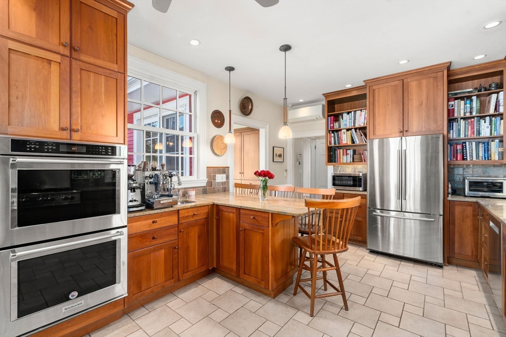 54 Arborway Boston, MA 02130 - Photo 9 of 29 a kitchen with stainless steel appliances granite countertop a refrigerator and a stove top oven