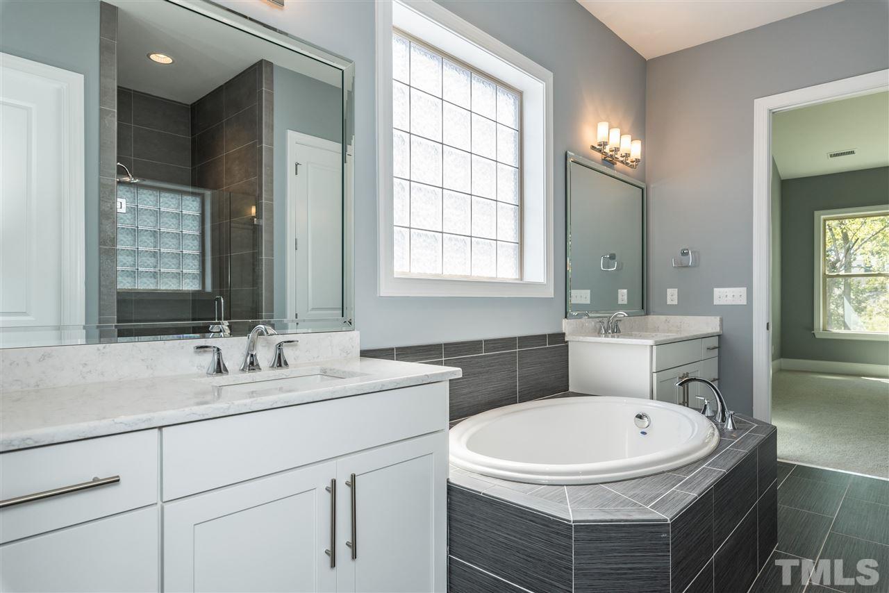 5273 Aleppo Lane, Unit 5 Raleigh, NC 27613 - Photo 12 of 24 a bathroom with a sink a toilet a mirror and window