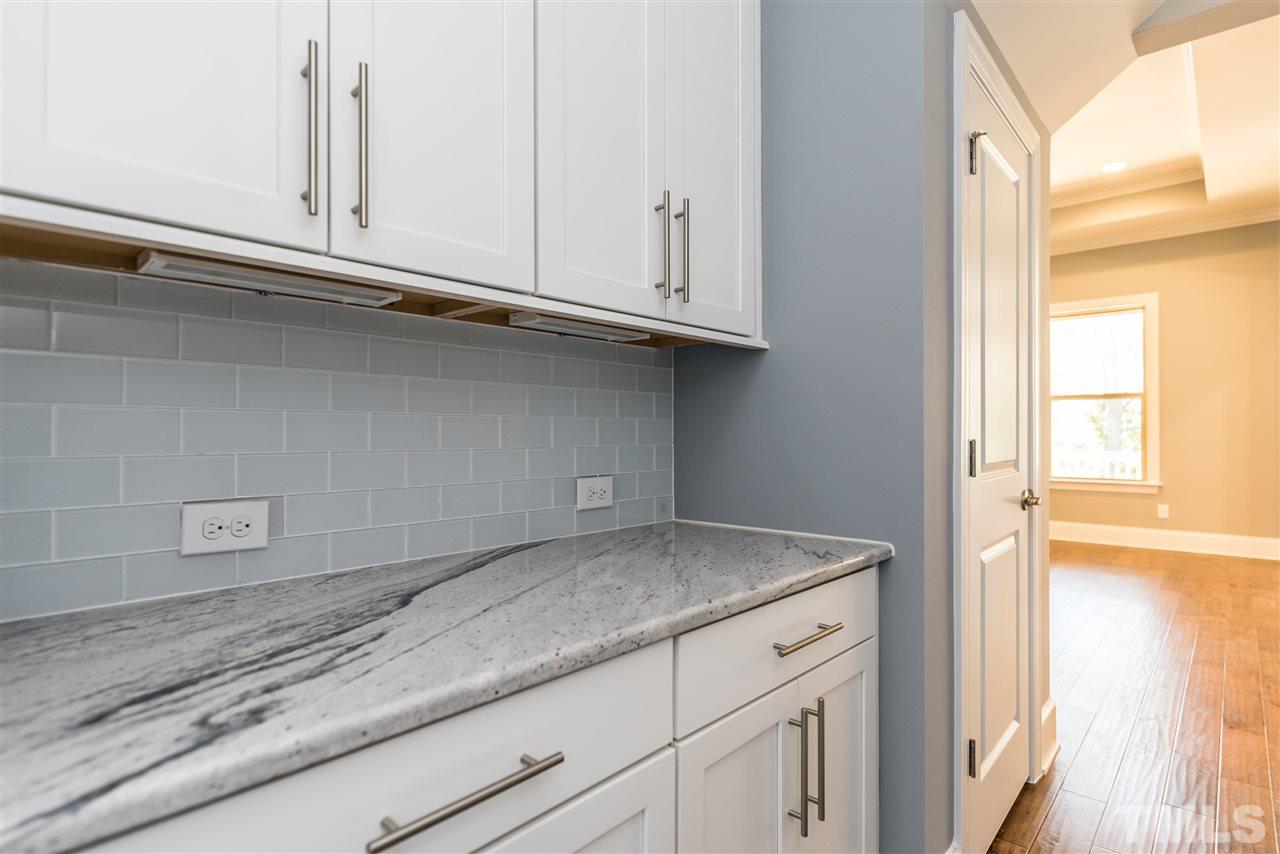 5273 Aleppo Lane, Unit 5 Raleigh, NC 27613 - Photo 4 of 24 a kitchen with granite countertop white cabinets and a wooden floor
