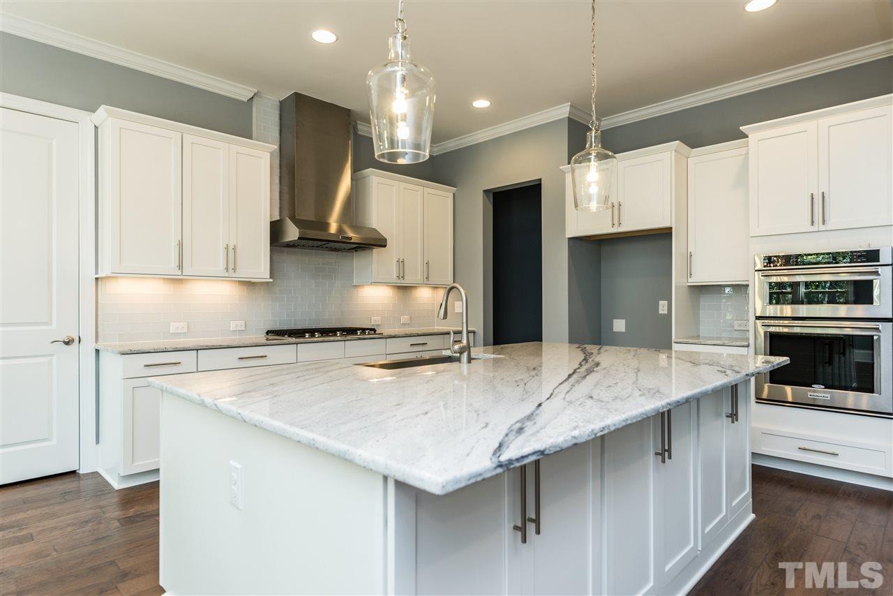 5273 Aleppo Lane, Unit 5 Raleigh, NC 27613 - Photo 5 of 24 a kitchen with stainless steel appliances granite countertop a sink a stove and a refrigerator
