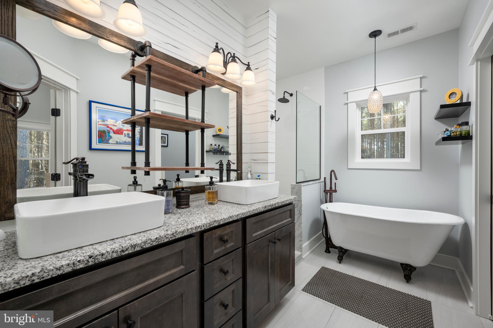 19668 Beaver Dam Road Lewes, DE 19958 - Photo 26 of 50 a spacious bathroom with double vanity sink a mirror and a bathtub