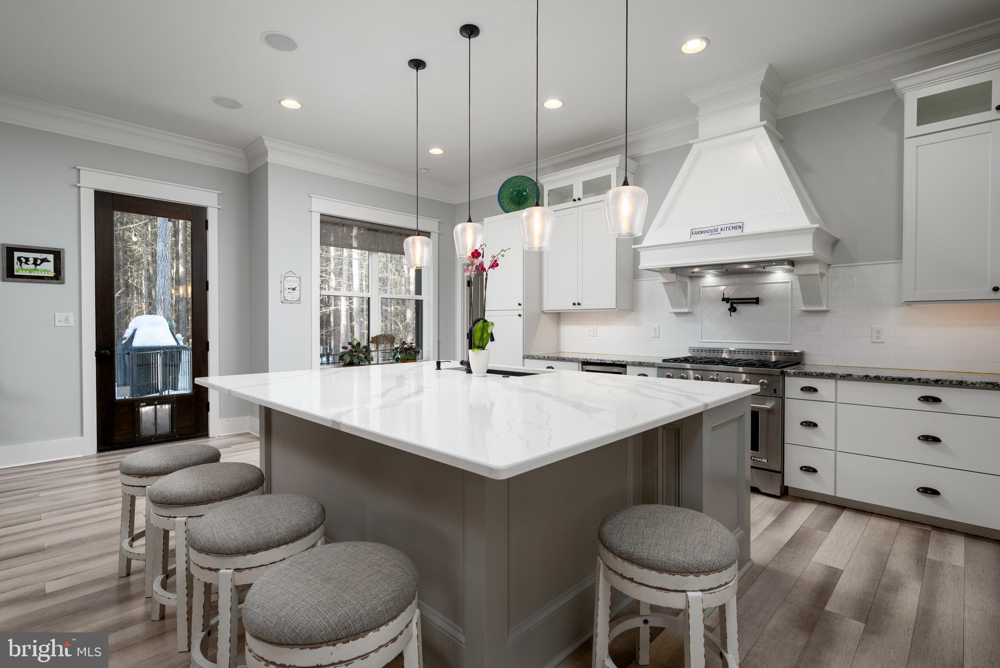 19668 Beaver Dam Road Lewes, DE 19958 - Photo 5 of 50 a kitchen with a stove a sink dishwasher a dining table and chairs with wooden floor