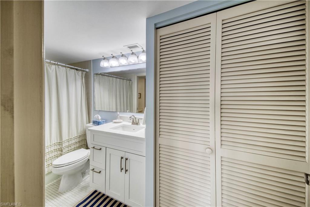 3 Bluebill Avenue, Unit 808 Naples, FL 34108 - Photo 25 of 25 a bathroom with a toilet a sink and mirror