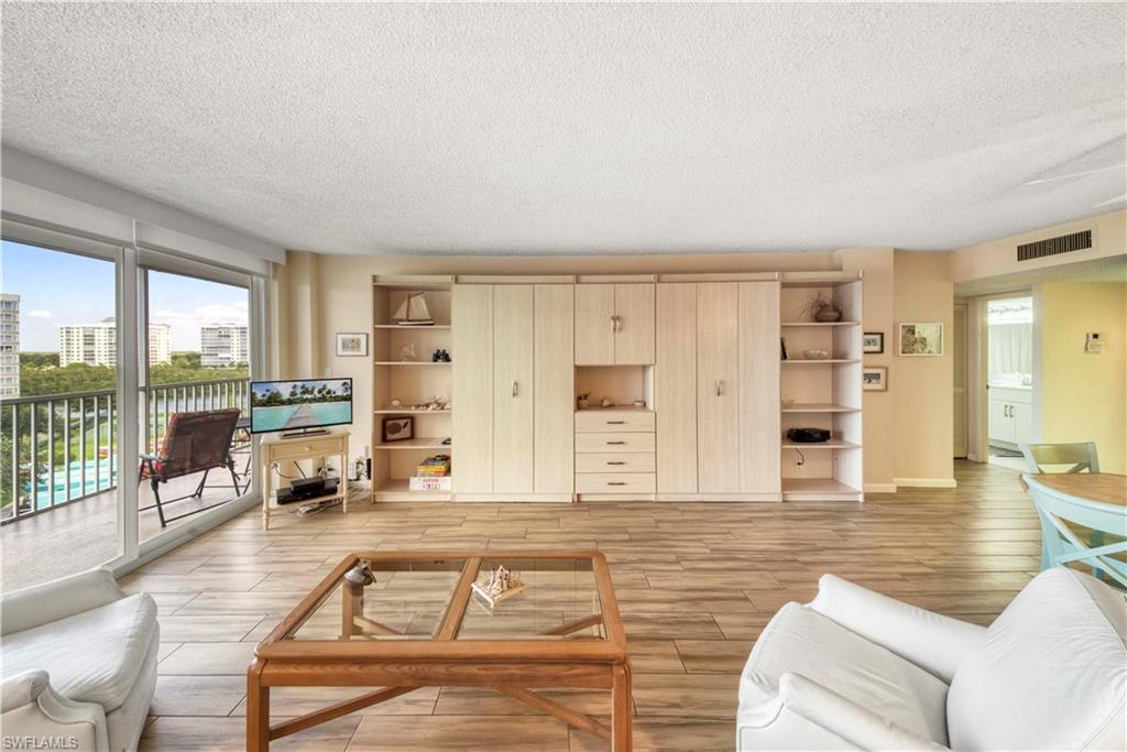 3 Bluebill Avenue, Unit 808 Naples, FL 34108 - Photo 10 of 25 a living room with furniture large windows and wooden floor