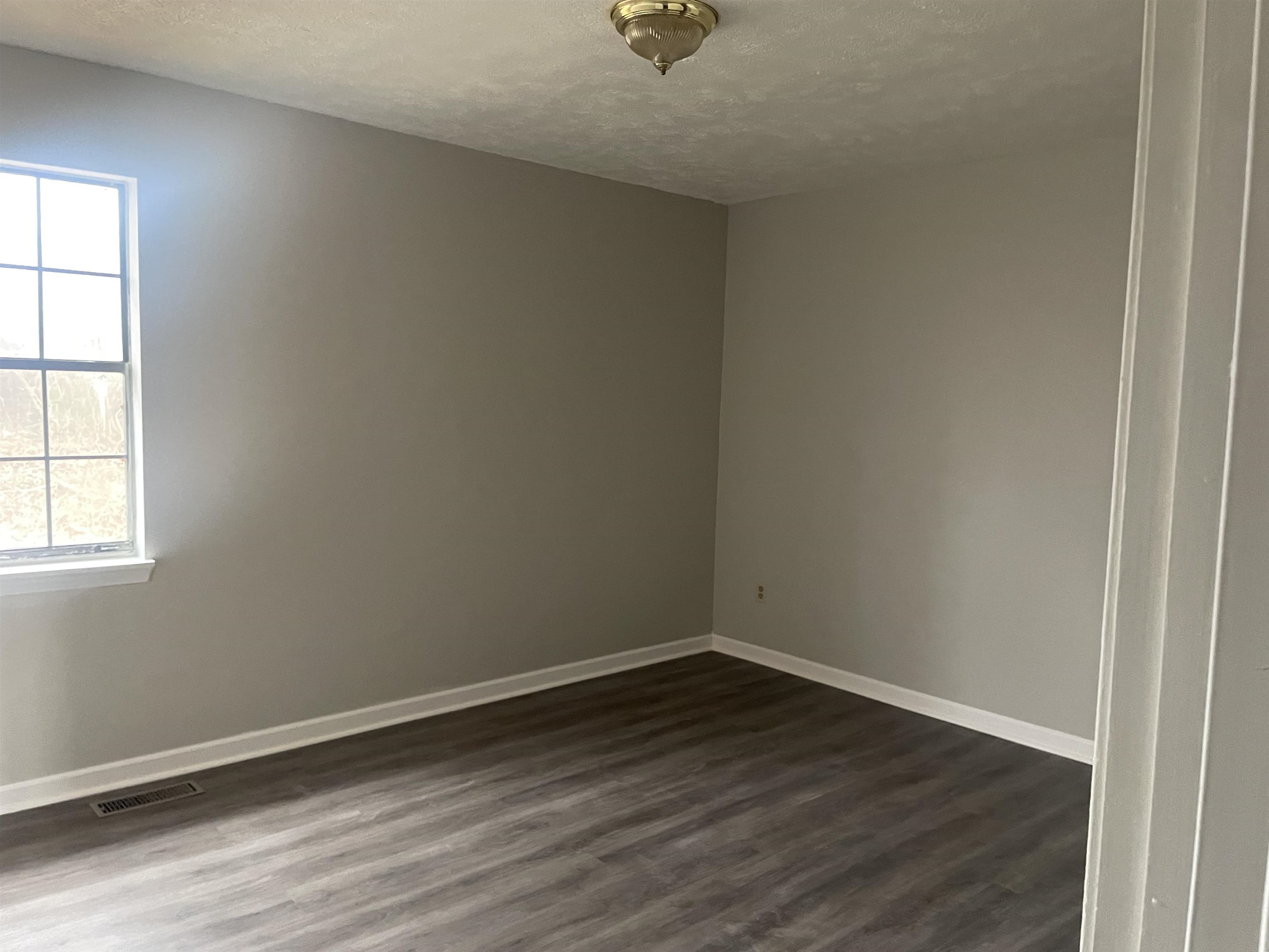 54 Cinnamon Drive Jackson, TN 38305 - Photo 2 of 7 an empty room with wooden floor and windows