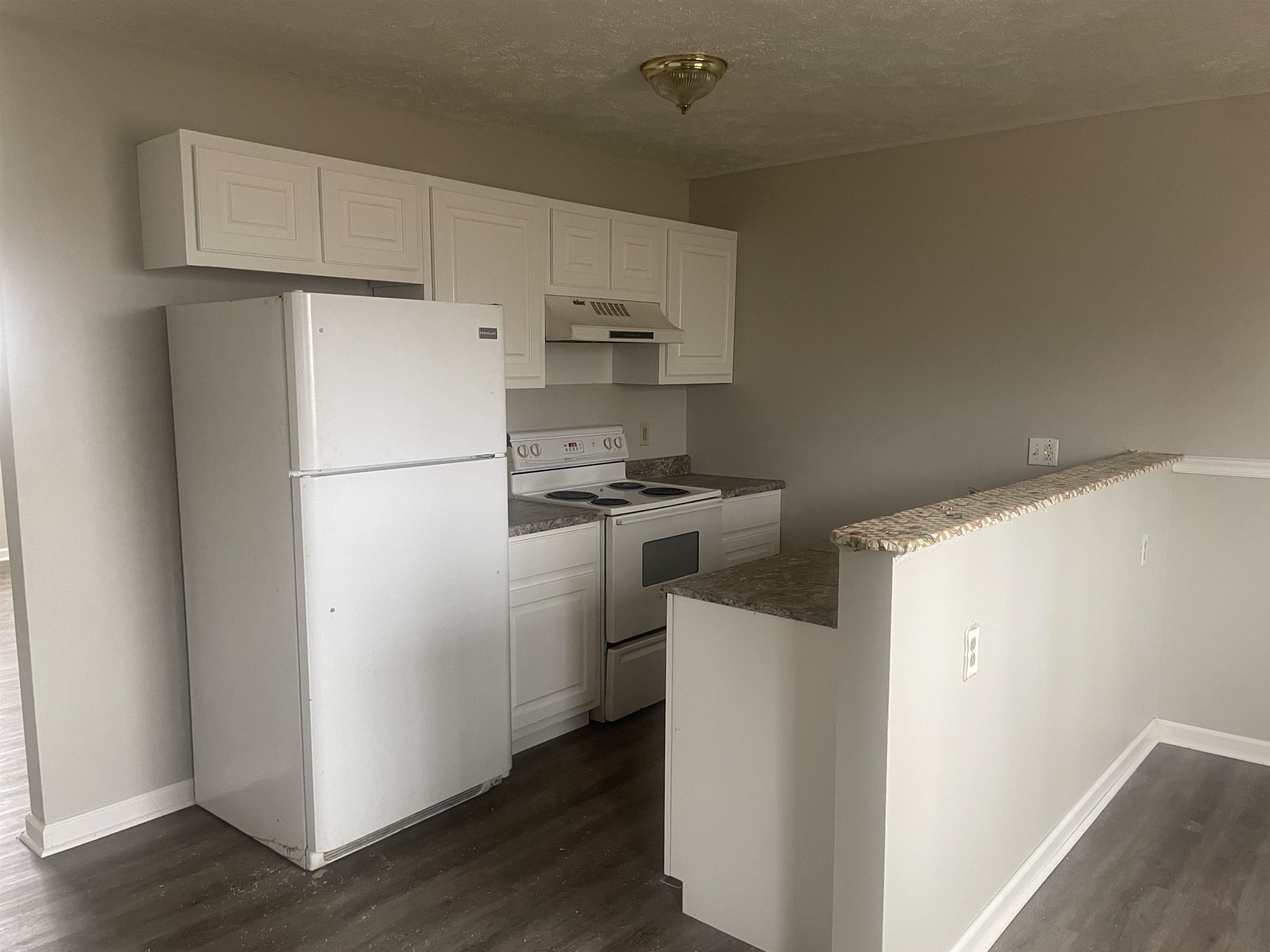 54 Cinnamon Drive Jackson, TN 38305 - Photo 5 of 7 a kitchen with a refrigerator a stove top oven and wooden floor
