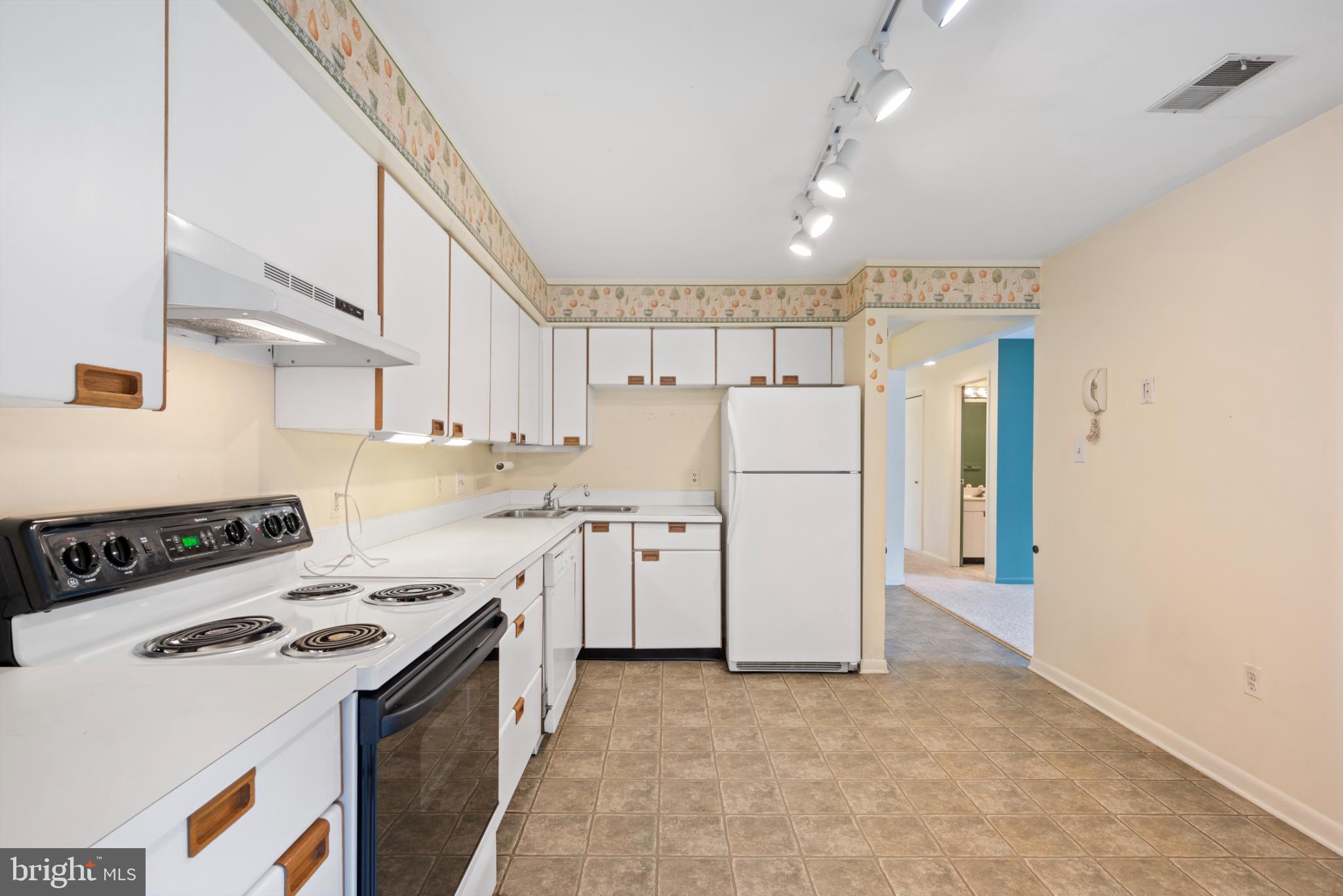 2201 Woodbox Lane, Unit 2201B Baltimore, MD 21209 - Photo 11 of 45 a kitchen with white cabinets and white appliances