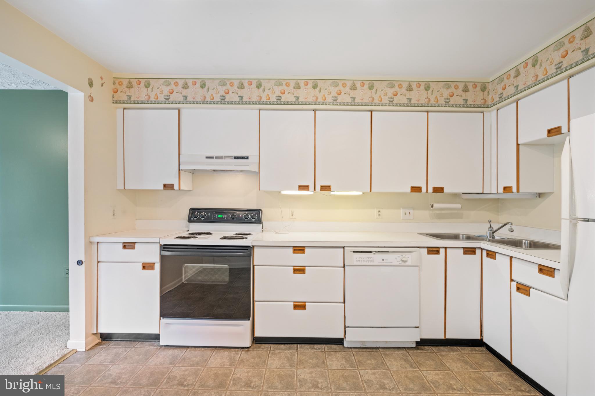 2201 Woodbox Lane, Unit 2201B Baltimore, MD 21209 - Photo 12 of 45 a kitchen with granite countertop white cabinets and white appliances