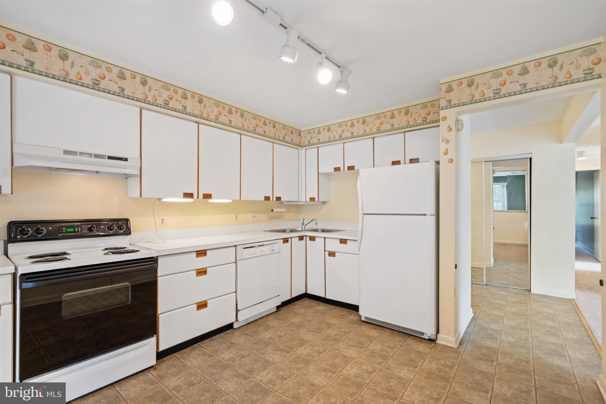2201 Woodbox Lane, Unit 2201B Baltimore, MD 21209 - Photo 13 of 45 a kitchen with granite countertop a refrigerator stove a sink and cabinets