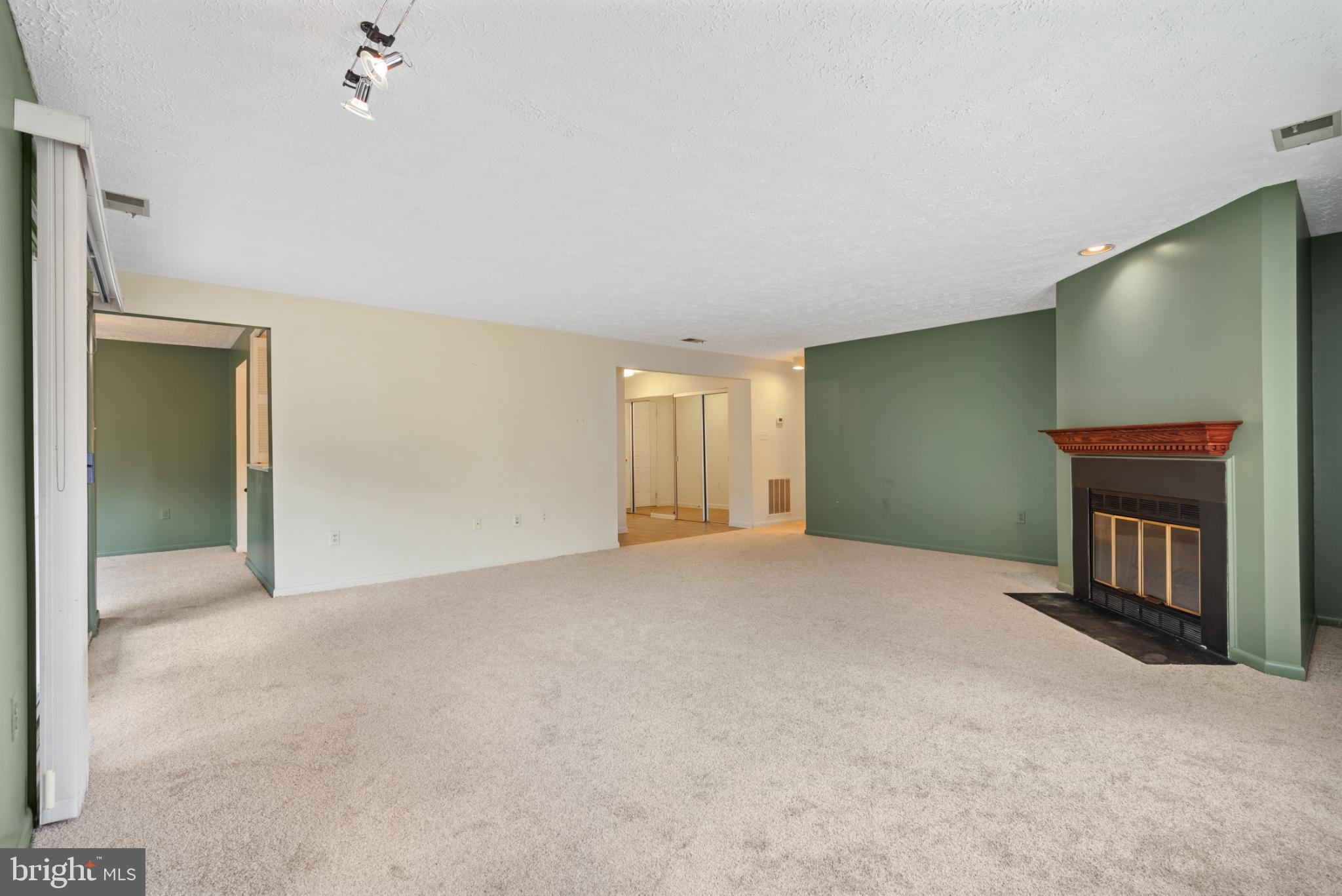 2201 Woodbox Lane, Unit 2201B Baltimore, MD 21209 - Photo 16 of 45 a view of an empty room with a fireplace and a window