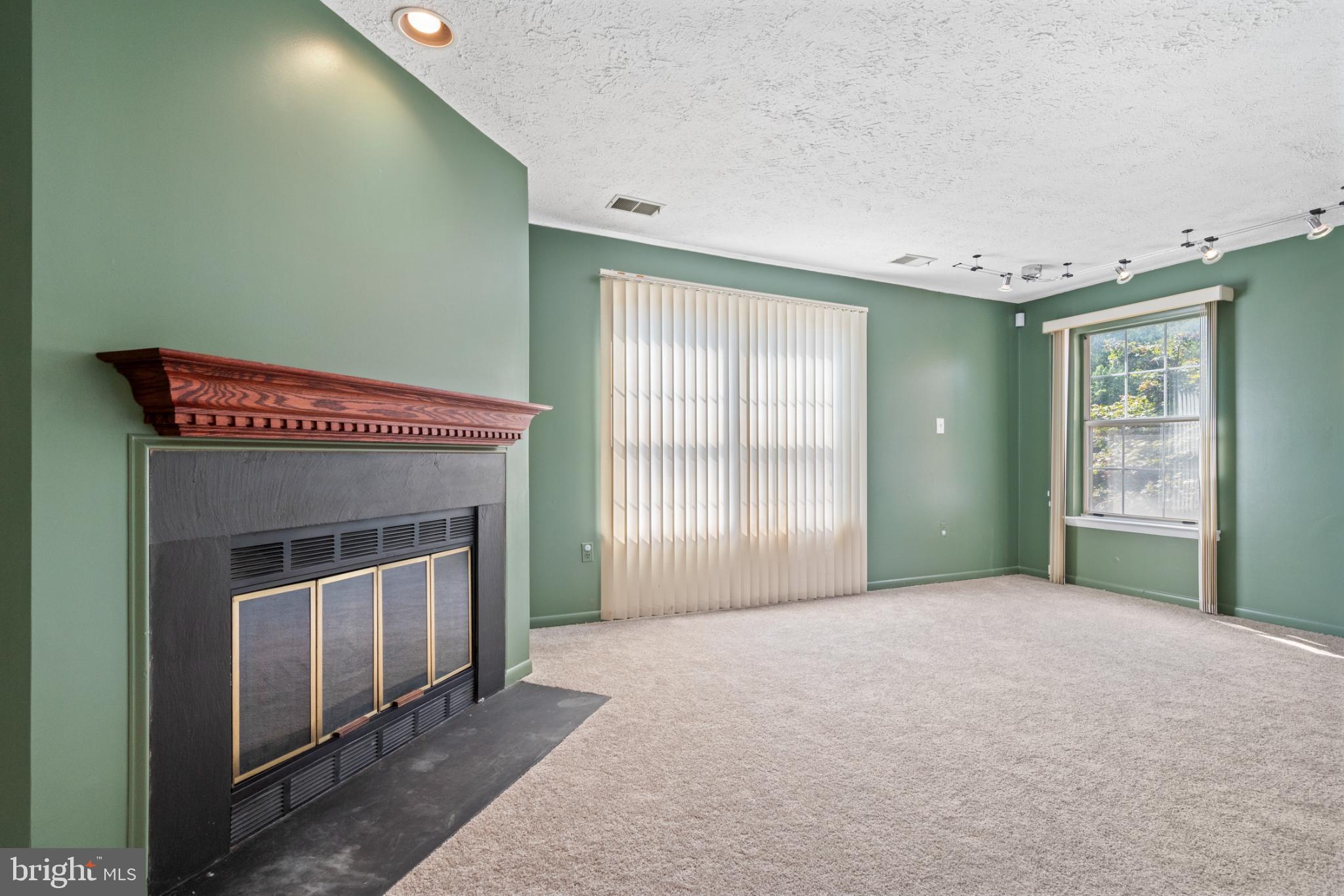2201 Woodbox Lane, Unit 2201B Baltimore, MD 21209 - Photo 21 of 45 a view of an empty room with a fireplace and a window