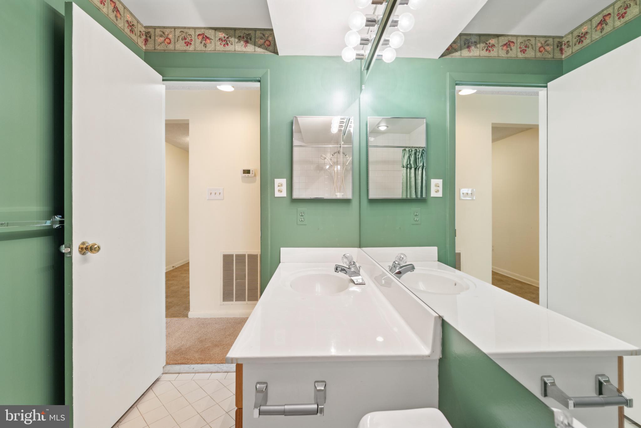 2201 Woodbox Lane, Unit 2201B Baltimore, MD 21209 - Photo 28 of 45 a bathroom with a sink a toilet and mirror