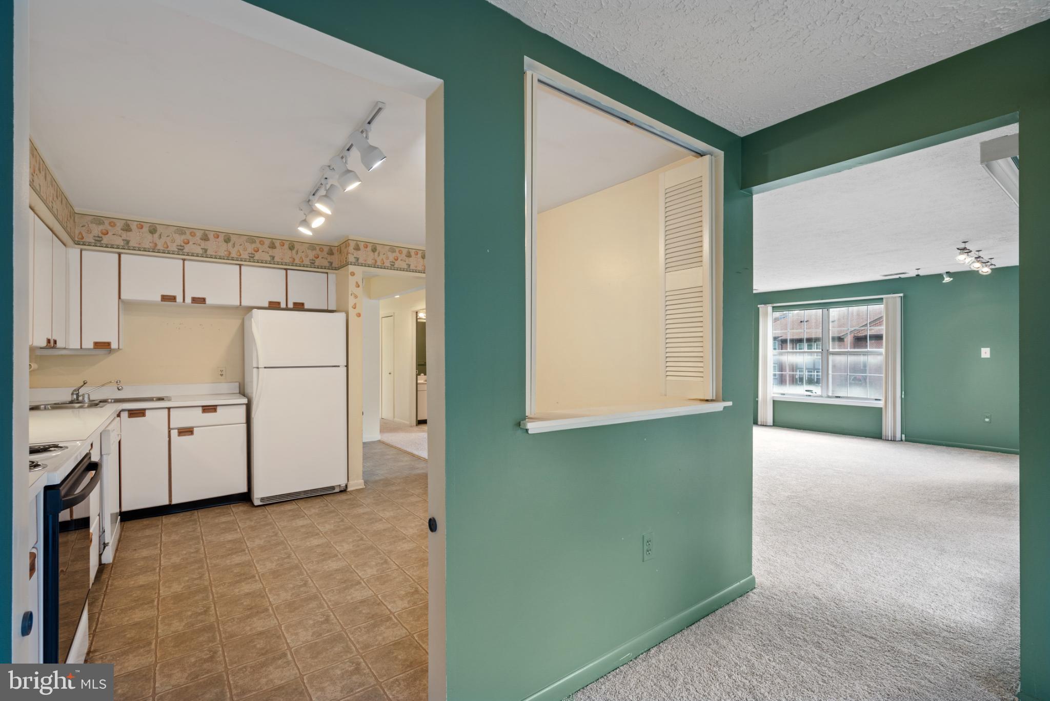2201 Woodbox Lane, Unit 2201B Baltimore, MD 21209 - Photo 10 of 45 a view of a kitchen with refrigerator and white cabinets