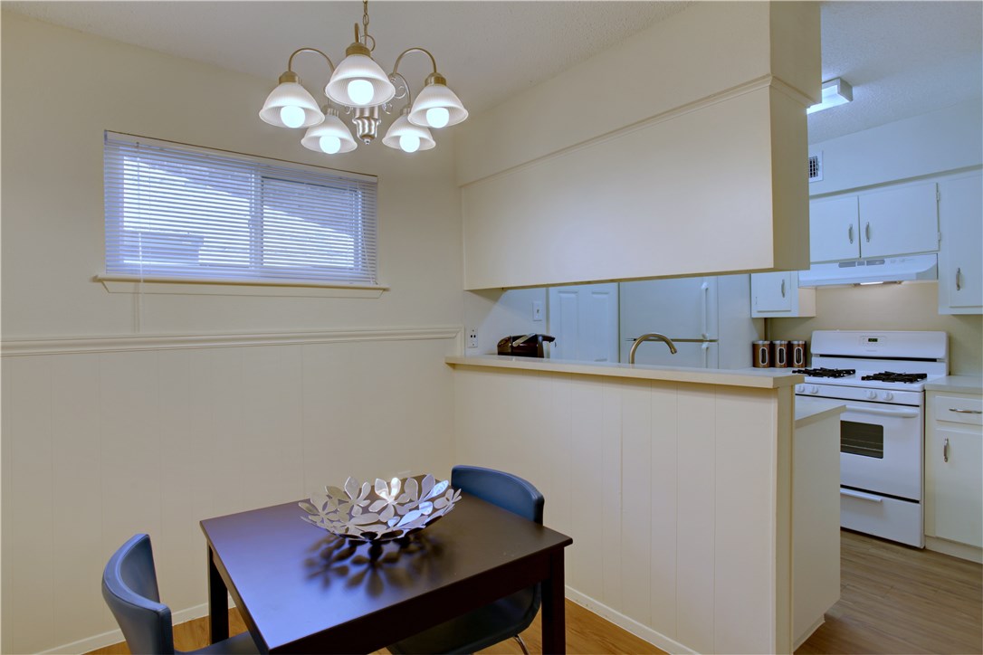 816 West N Loop Boulevard, Unit 106 Austin, TX 78756 - Photo 11 of 21 a kitchen with stainless steel appliances granite countertop a dining table chairs a stove top oven and chandelier