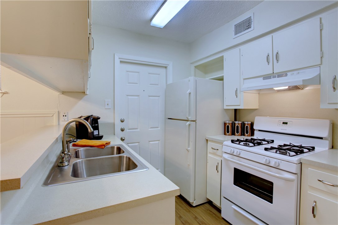 816 West N Loop Boulevard, Unit 106 Austin, TX 78756 - Photo 13 of 21 a kitchen with stainless steel appliances a stove a microwave and a refrigerator