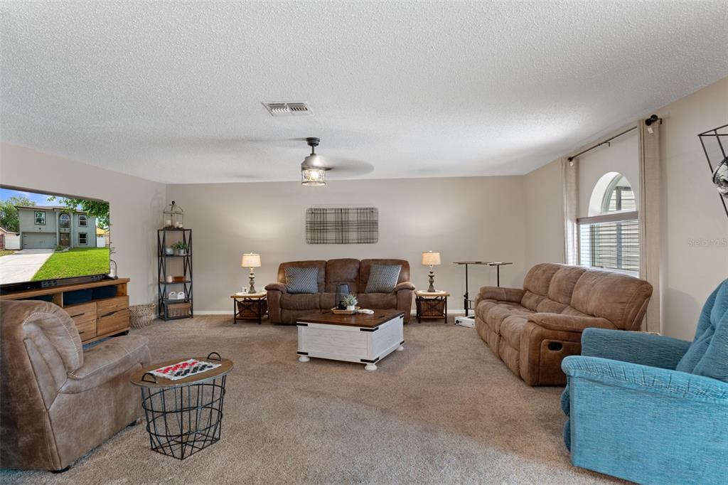 2451 Deltona Boulevard Spring Hill, FL 34606 - Photo 19 of 68 a living room with furniture and a flat screen tv
