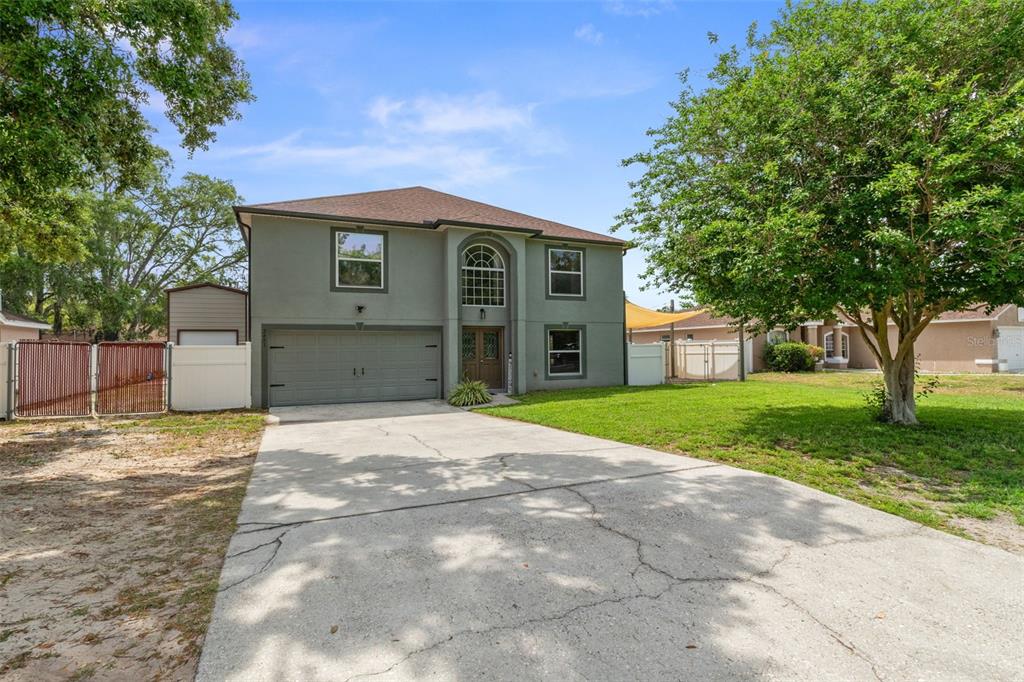 2451 Deltona Boulevard Spring Hill, FL 34606 - Photo 62 of 68 a front view of a house with a yard and garage