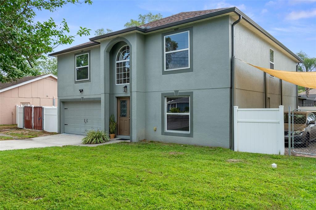 2451 Deltona Boulevard Spring Hill, FL 34606 - Photo 63 of 68 a front view of a house with a yard and garage