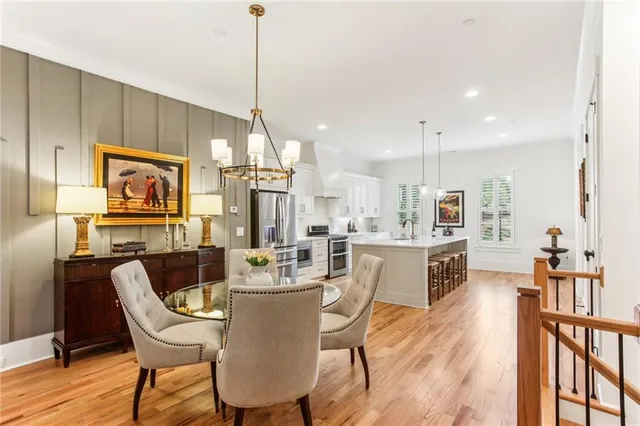 a dining room with furniture a chandelier and wooden floor