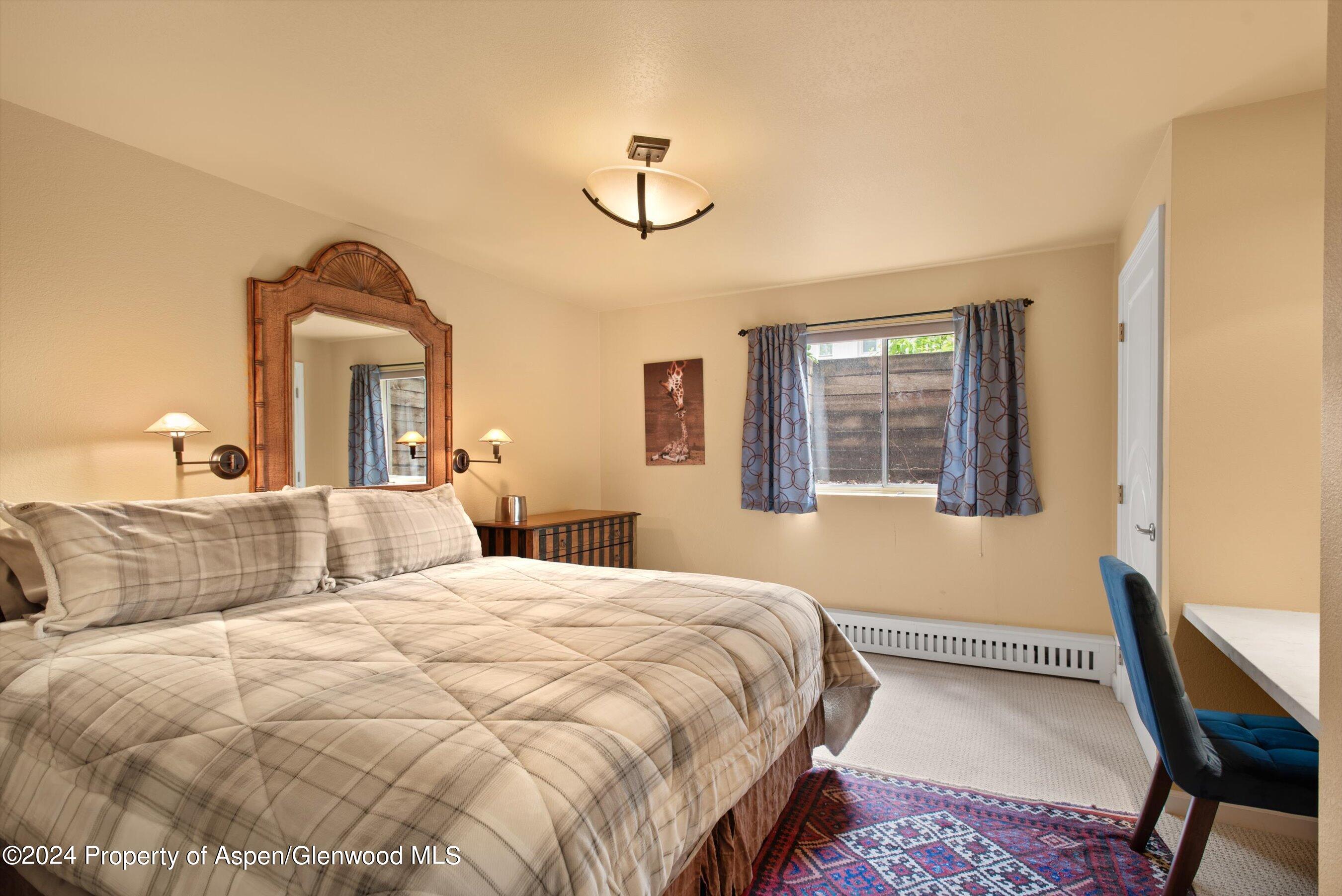 153 Wren Court Basalt, CO 81621 - Photo 17 of 21 a bedroom with a large bed and a chandelier