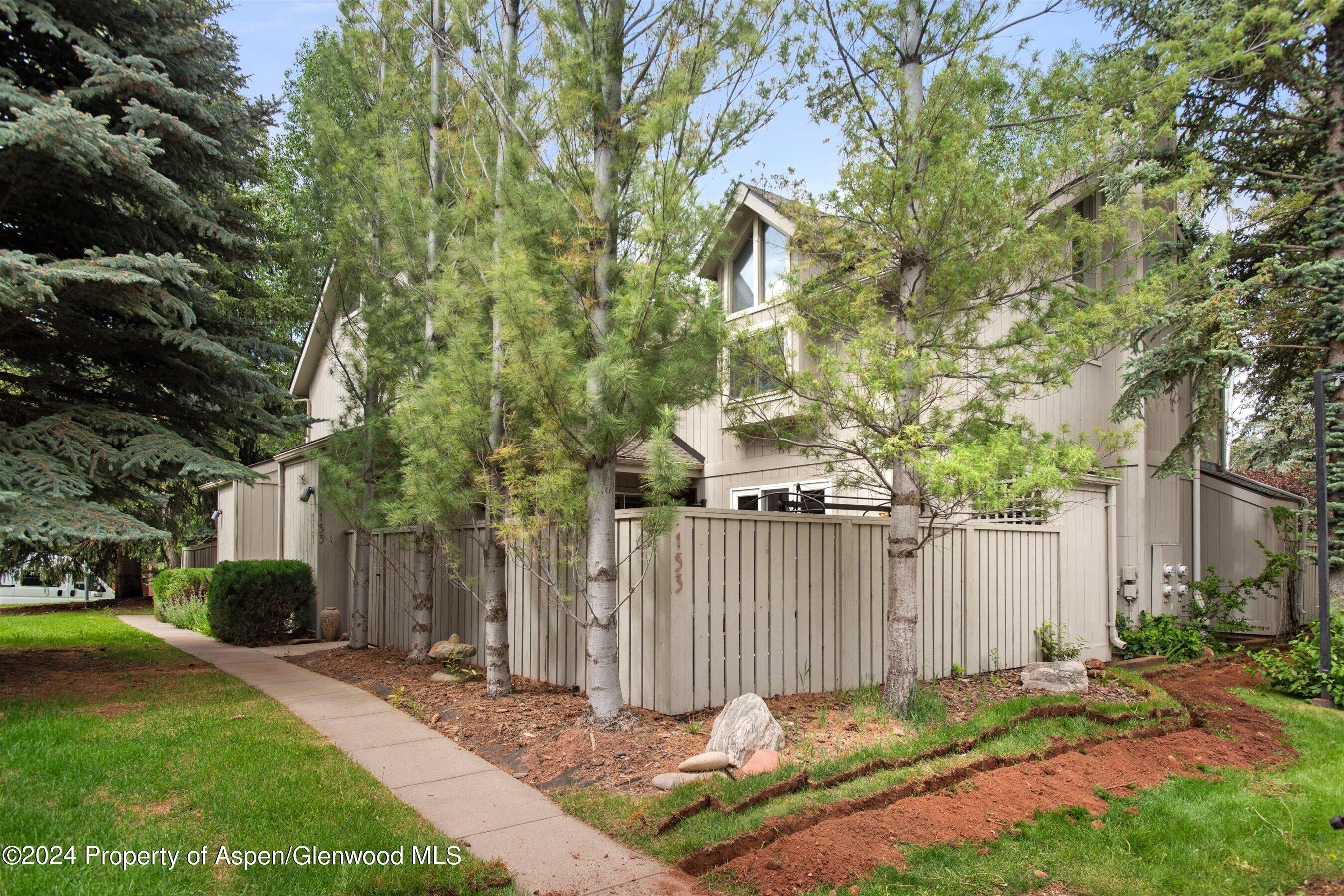 153 Wren Court Basalt, CO 81621 - Photo 2 of 21 a backyard of a house with plants and trees beside of it