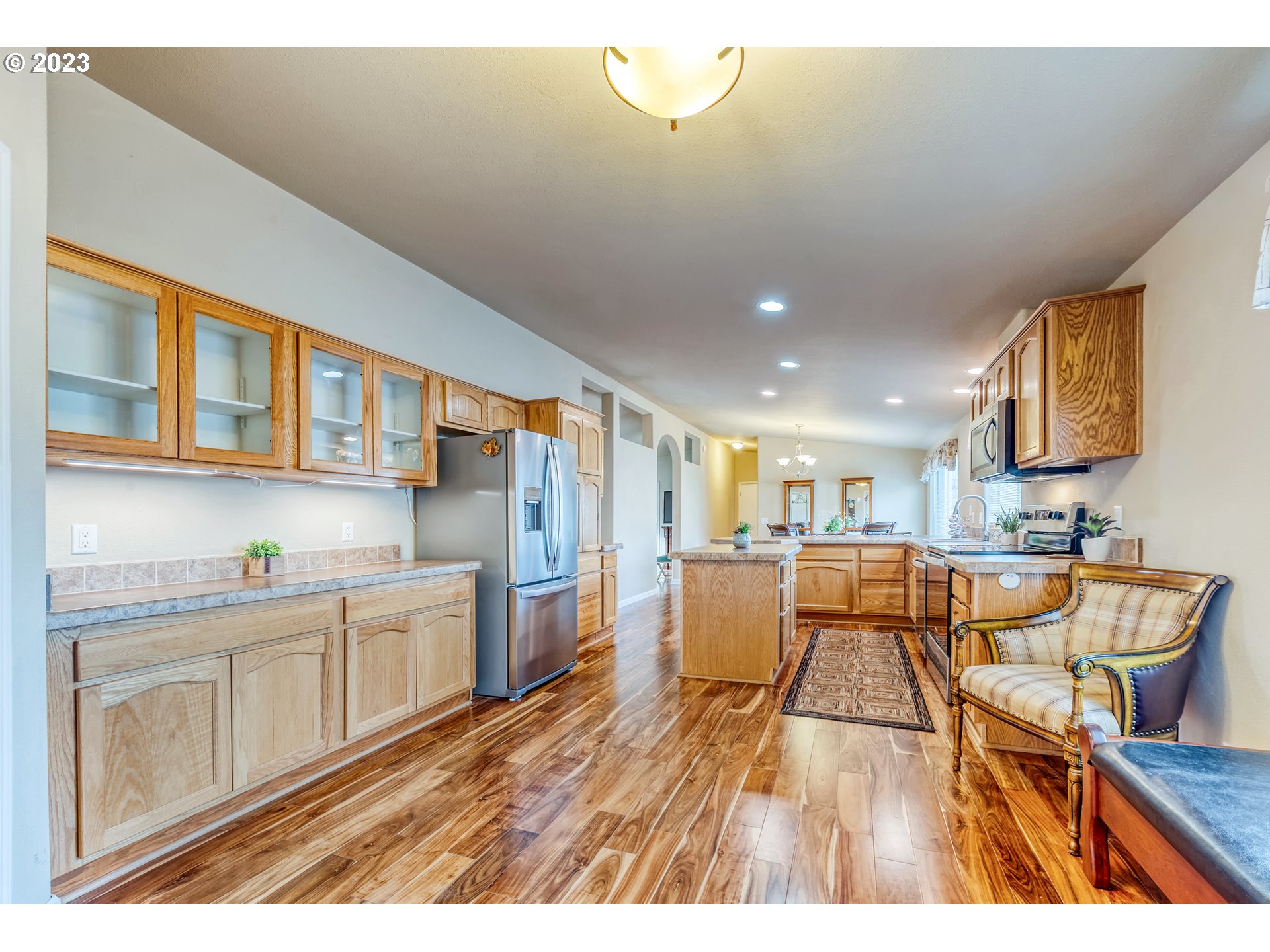 2601 Maia Loop Springfield, OR 97477 - Photo 11 of 29 a open kitchen with stainless steel appliances granite countertop a refrigerator a sink dishwasher a dining table and chairs with wooden floor