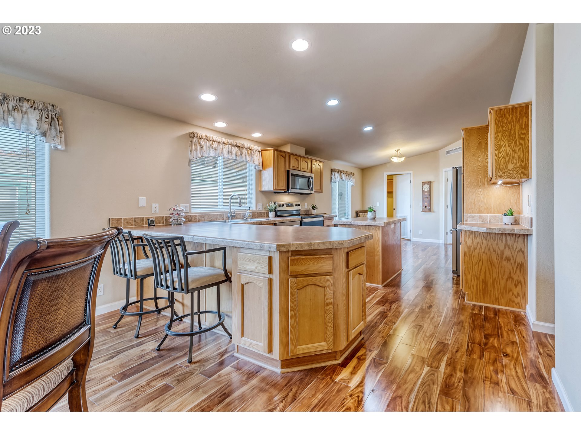 2601 Maia Loop Springfield, OR 97477 - Photo 9 of 29 a kitchen with stainless steel appliances granite countertop a stove top oven a sink a dining table and chairs