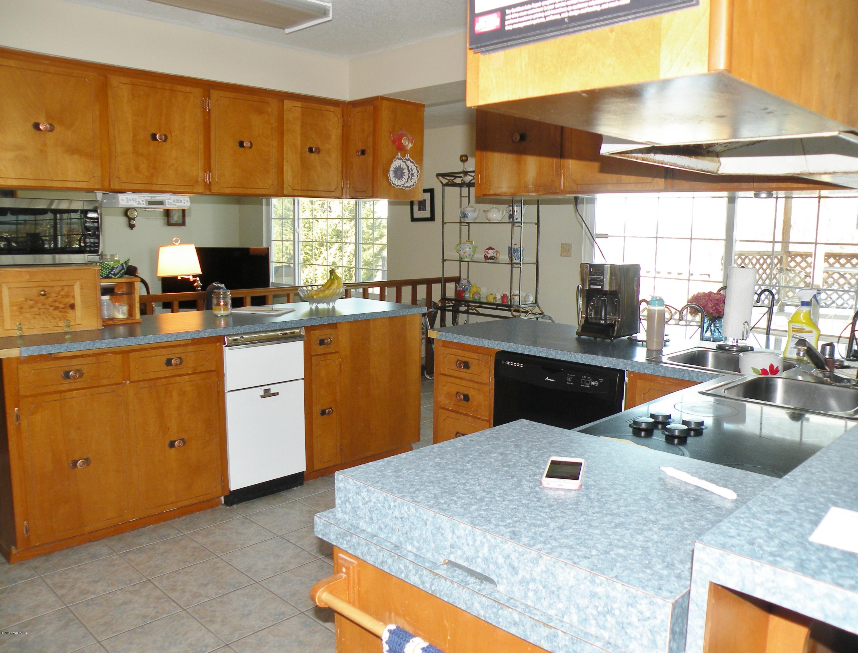 711 Meadowbrook Road Yakima, WA 98903 - Photo 7 of 22 a kitchen with stainless steel appliances granite countertop sink stove and cabinets