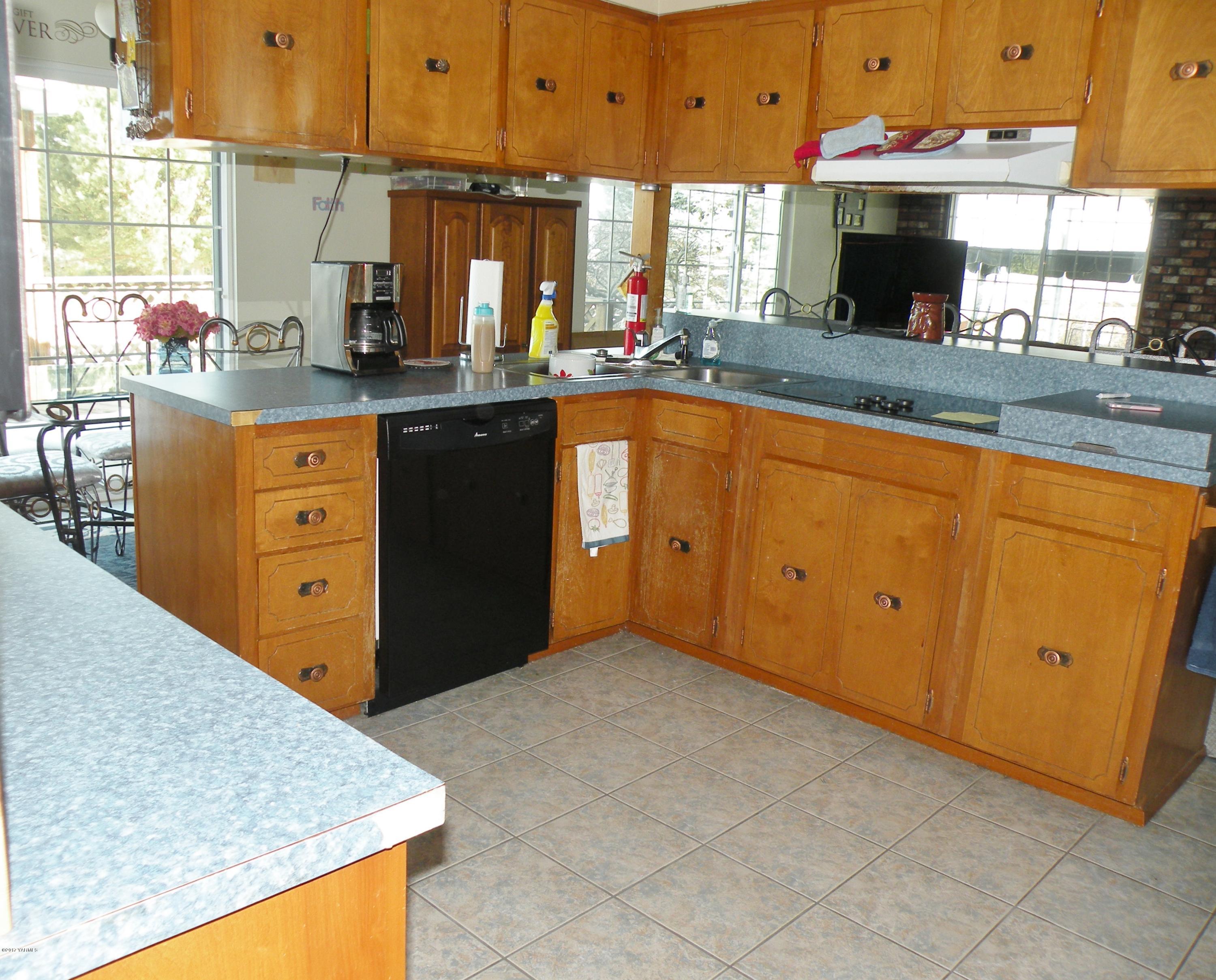 711 Meadowbrook Road Yakima, WA 98903 - Photo 8 of 22 a kitchen with stainless steel appliances granite countertop a stove a sink and a microwave