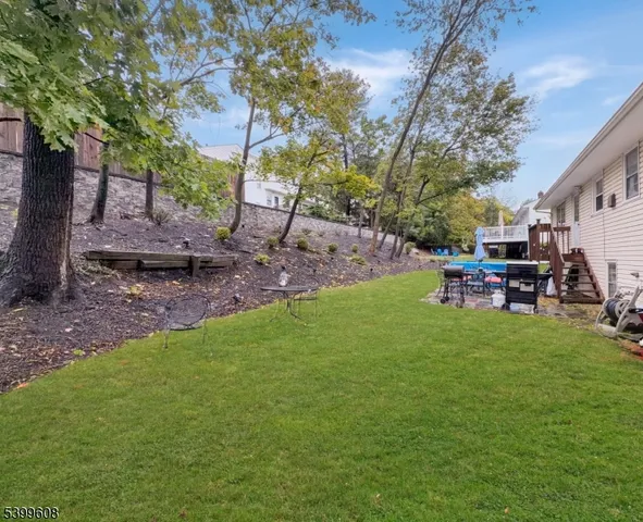 a view of a backyard with table and chairs with a tree