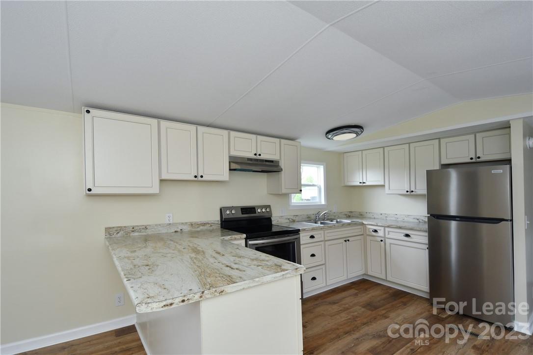 a kitchen with a sink a refrigerator and white cabinets