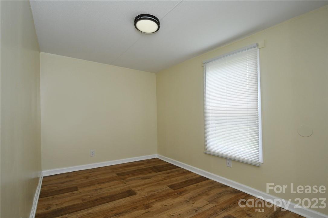 115 Buckhead Road, Unit 111 Harmony, NC 28634 - Photo 13 of 19 an empty room with wooden floor and windows