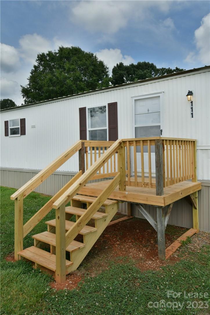 115 Buckhead Road, Unit 111 Harmony, NC 28634 - Photo 5 of 19 a view of a house with a wooden deck and a forest
