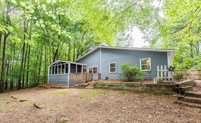 a front view of house with yard and trees in the background