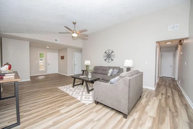 a living room with furniture and a wooden floor
