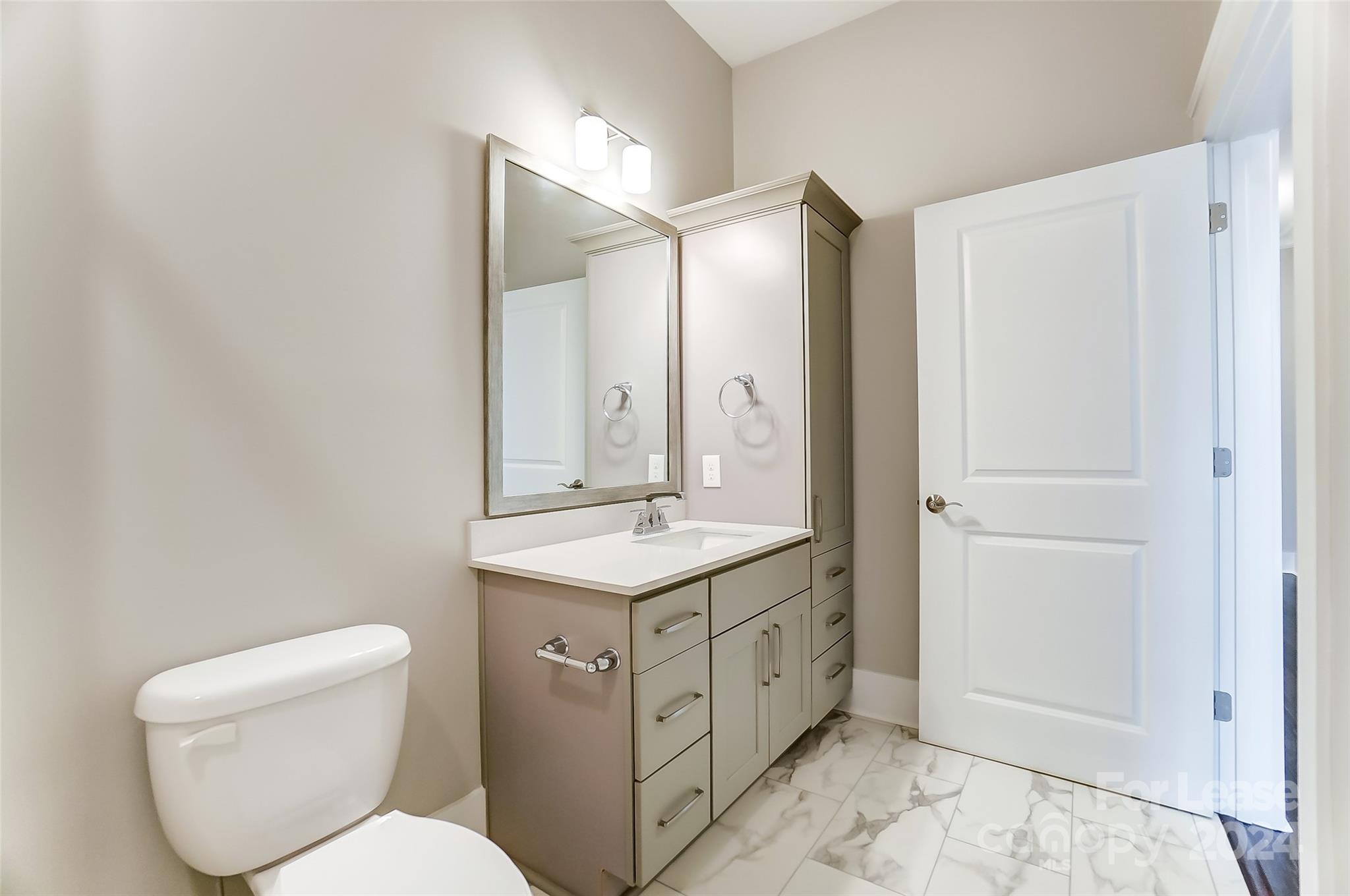 830 Providence Road, Unit 401 Charlotte, NC 28207 - Photo 21 of 24 a bathroom with a toilet sink and mirror