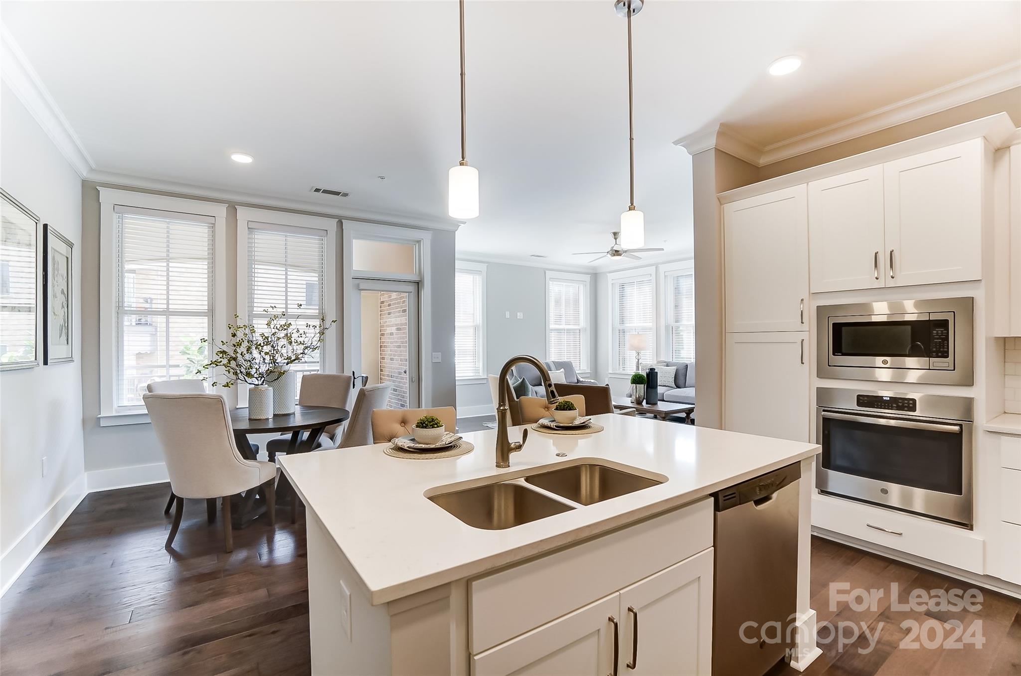 830 Providence Road, Unit 401 Charlotte, NC 28207 - Photo 8 of 24 a kitchen island with stainless steel appliances a kitchen island hardwood floor sink stove dining table and chairs
