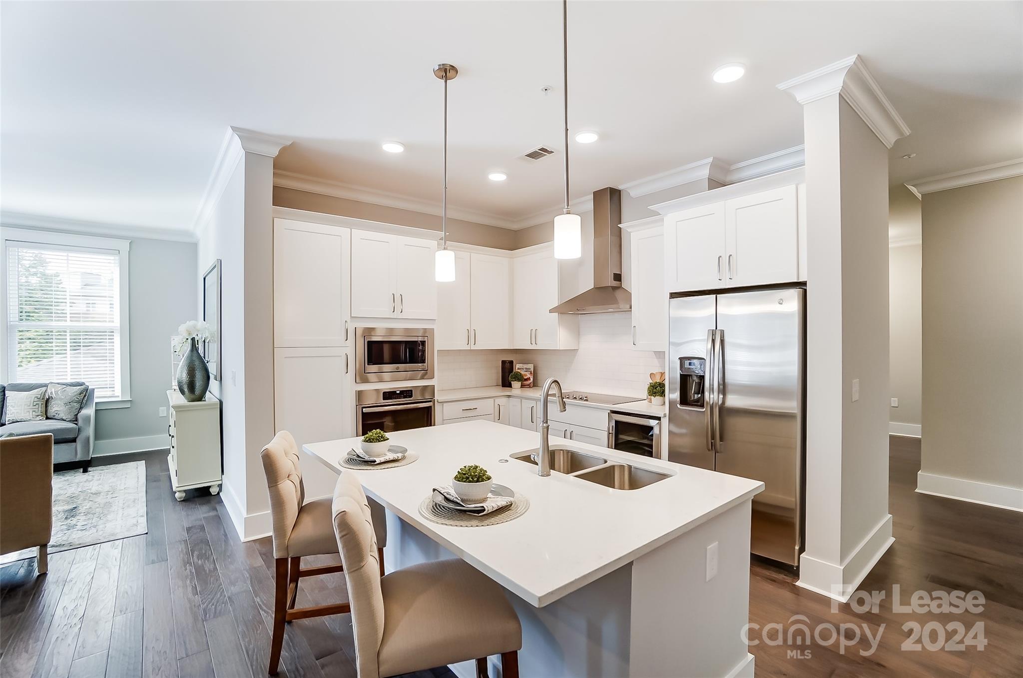 830 Providence Road, Unit 401 Charlotte, NC 28207 - Photo 9 of 24 a kitchen with kitchen island a refrigerator a stove a dining table and chairs