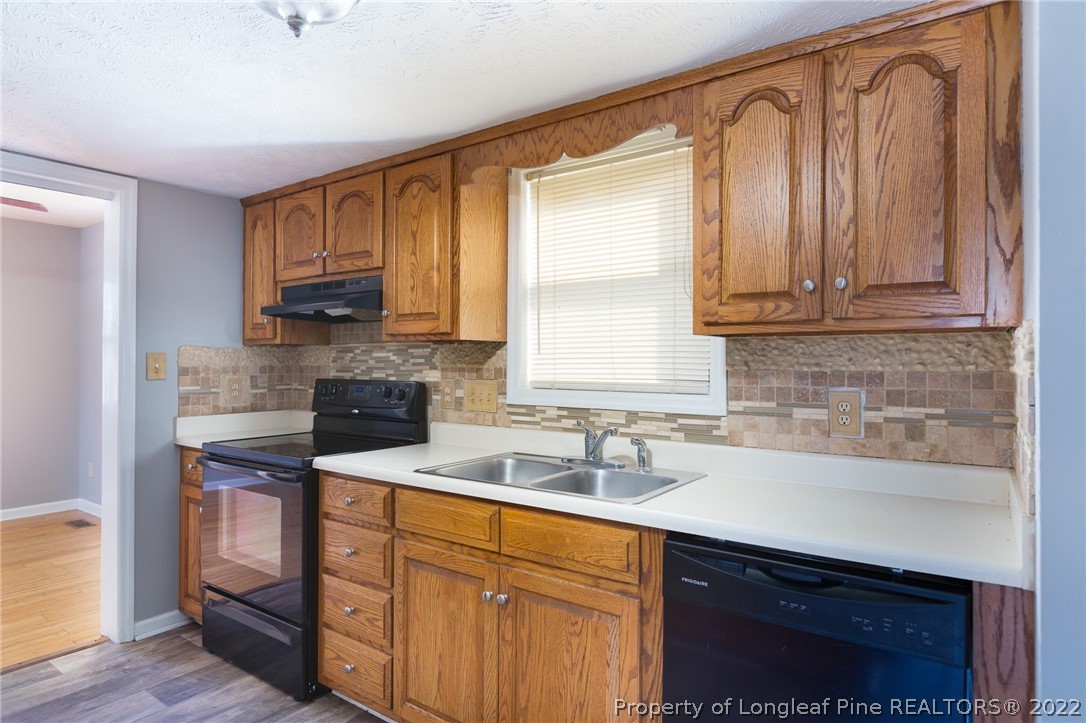 4629 Legion Road Hope Mills, NC 28348 - Photo 10 of 21 a kitchen with stainless steel appliances granite countertop a sink a stove cabinets and a counter top space