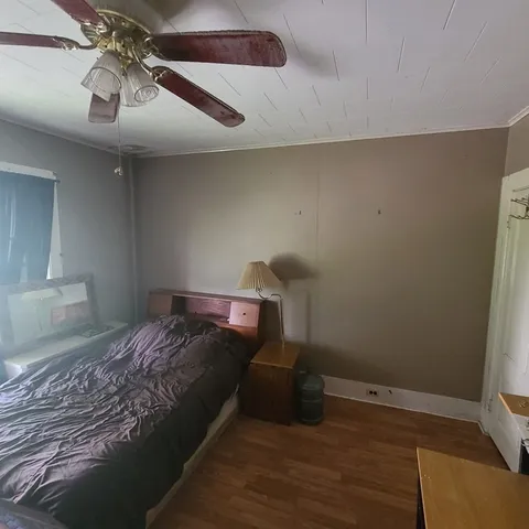 a bedroom with a bed and wooden floor
