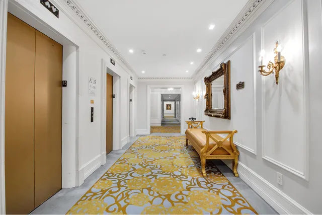 a view of a hallway to a livingroom with furniture and front door