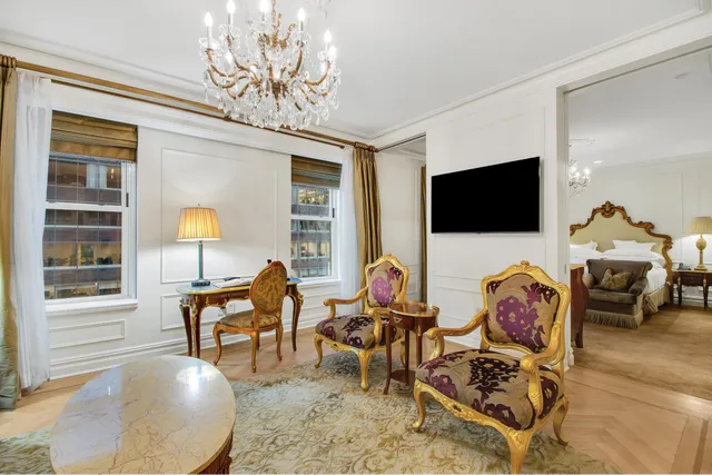 a living room with furniture a flat screen tv and a chandelier