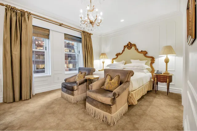 a spacious bedroom with a bed and a chandelier