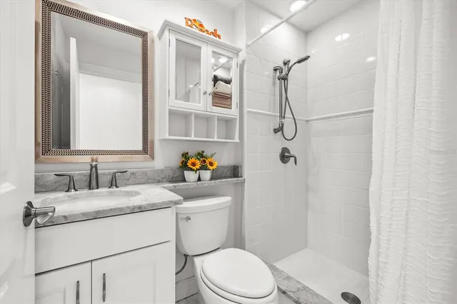 a bathroom with a granite countertop sink toilet and shower