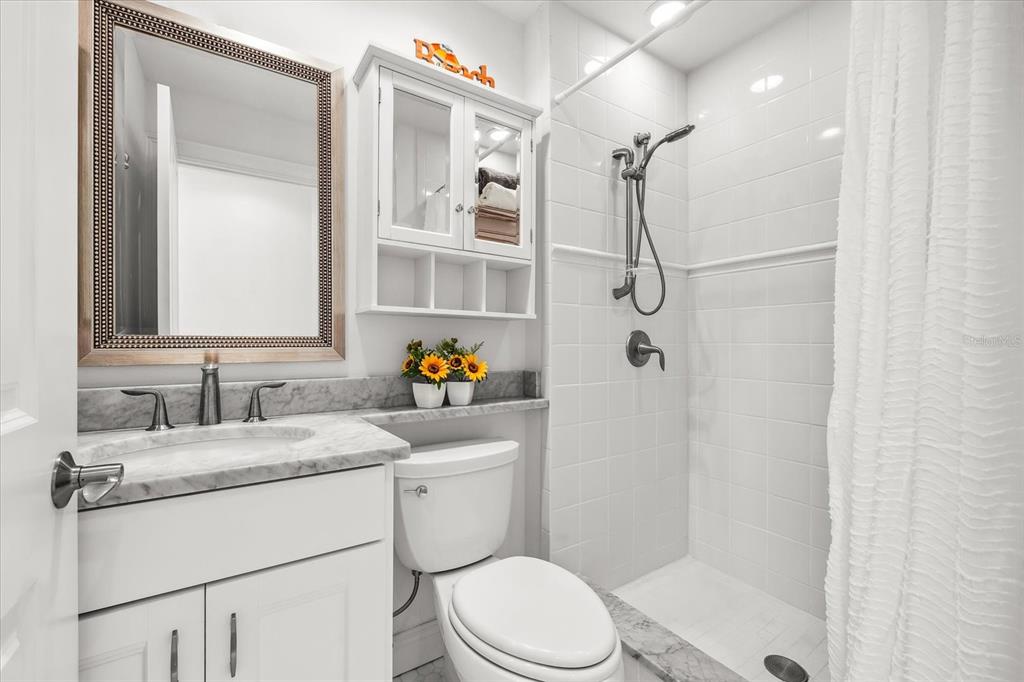 548 Beach Road, Unit 540A Sarasota, FL 34242 - Photo 27 of 77 a bathroom with a sink toilet vanity and shower
