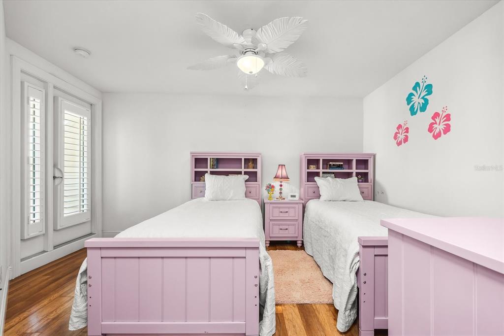 548 Beach Road, Unit 540A Sarasota, FL 34242 - Photo 28 of 77 a bedroom with a bed and a chandelier