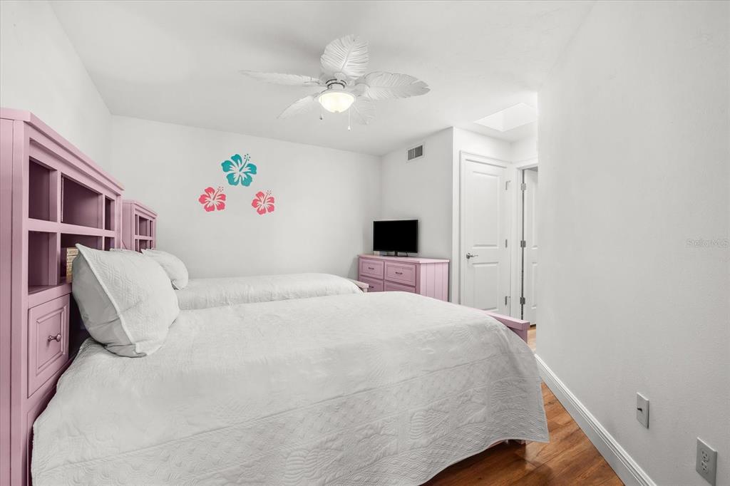 548 Beach Road, Unit 540A Sarasota, FL 34242 - Photo 29 of 77 a bedroom with a bed and a chandelier