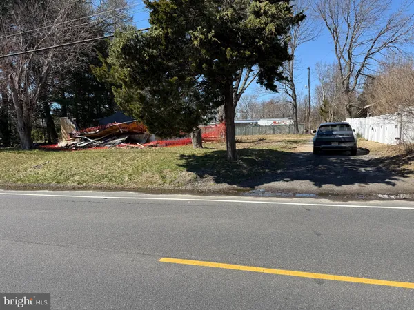 a view of a street with a bench and trees