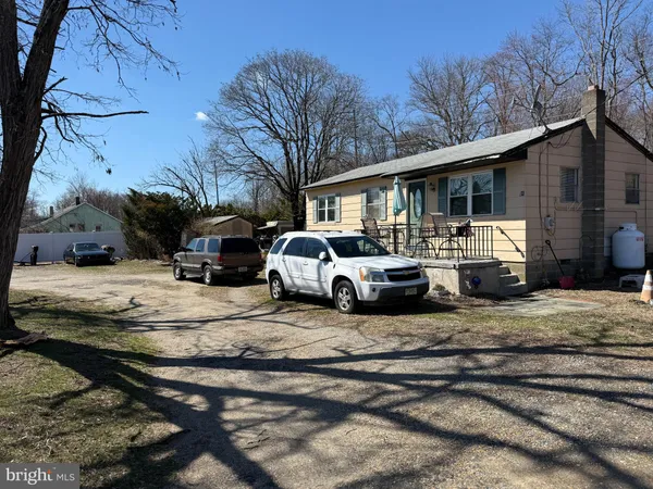 a front view of a house with cars parked on road